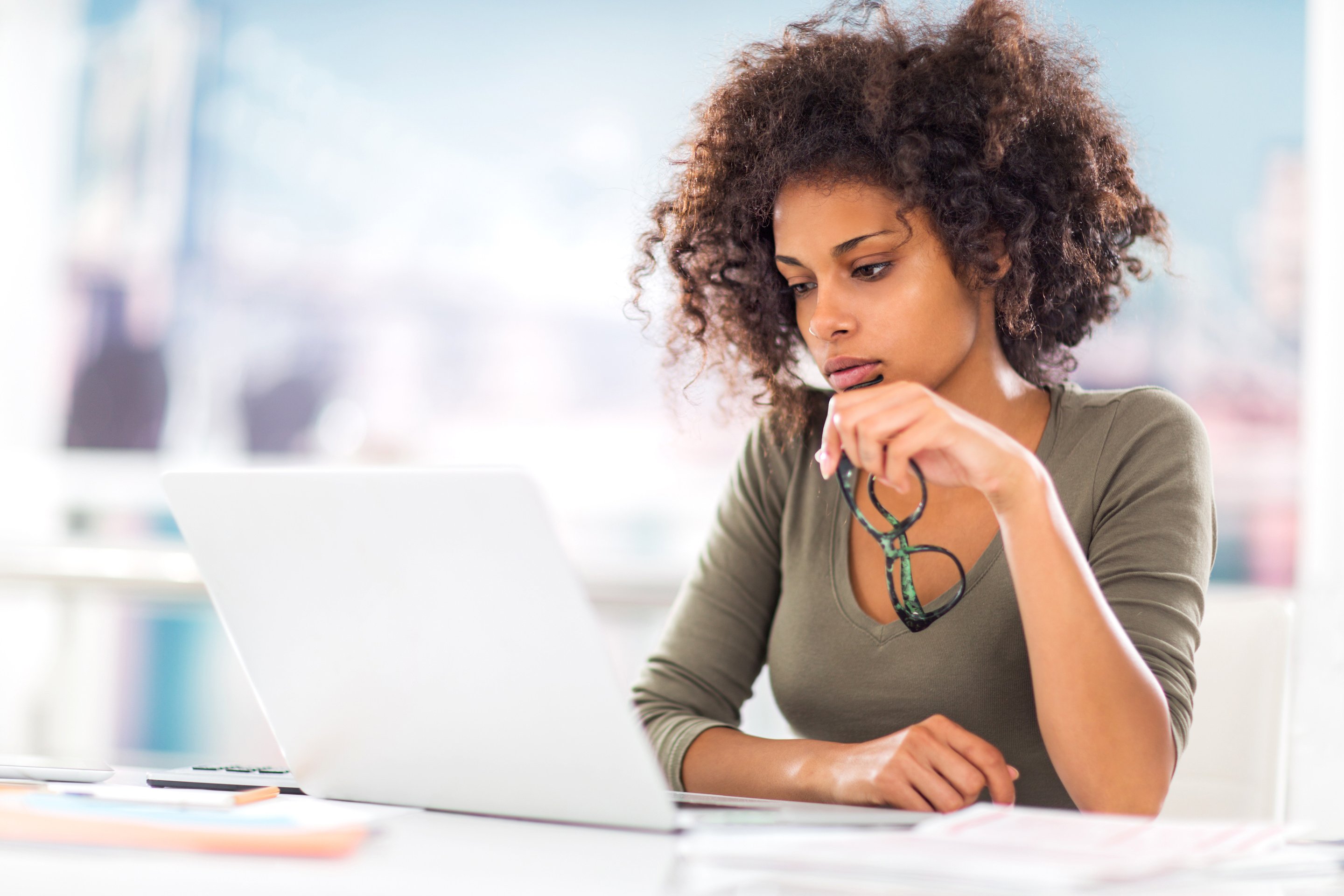 Worried African American woman using laptop.